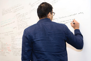 a man writing on a white board